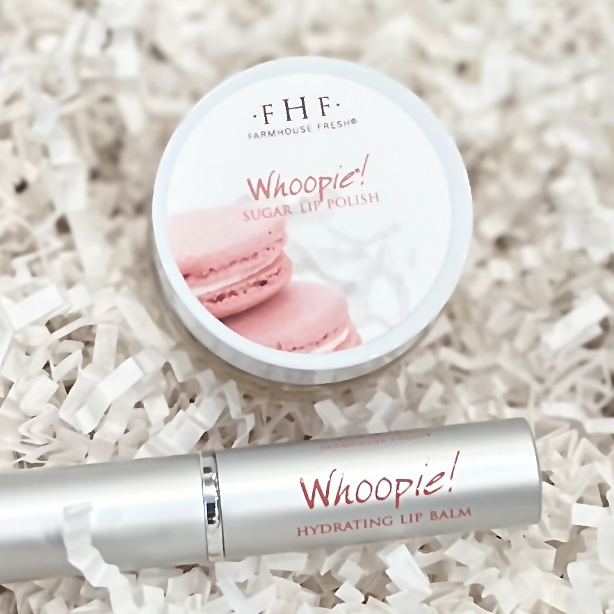 FarmHouse Fresh's Whoopie lip polish and lip balm sit in a basket of crinkle paper.