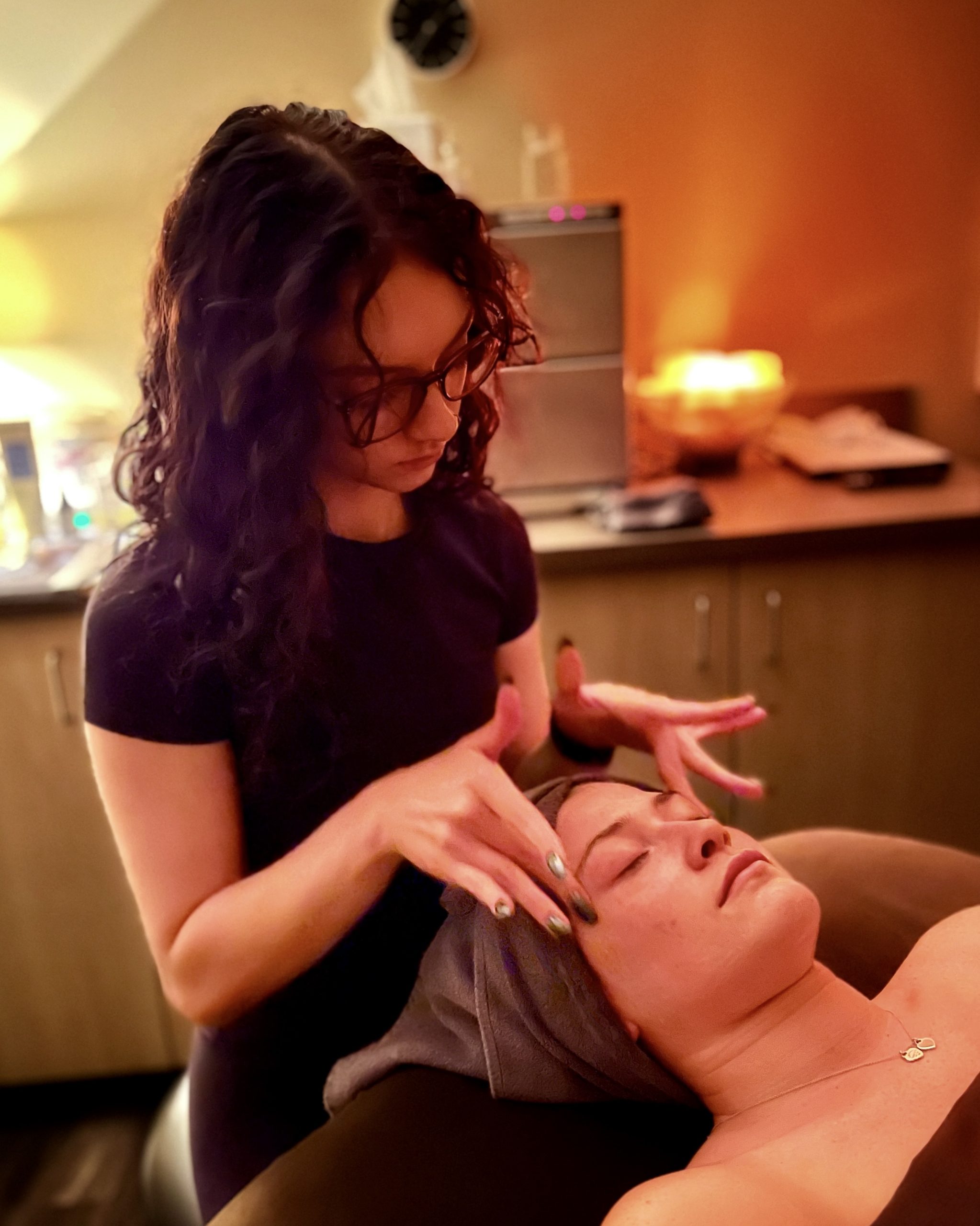 Our esthetician Emmy massages her guests' face during a Dermaplane Facial.