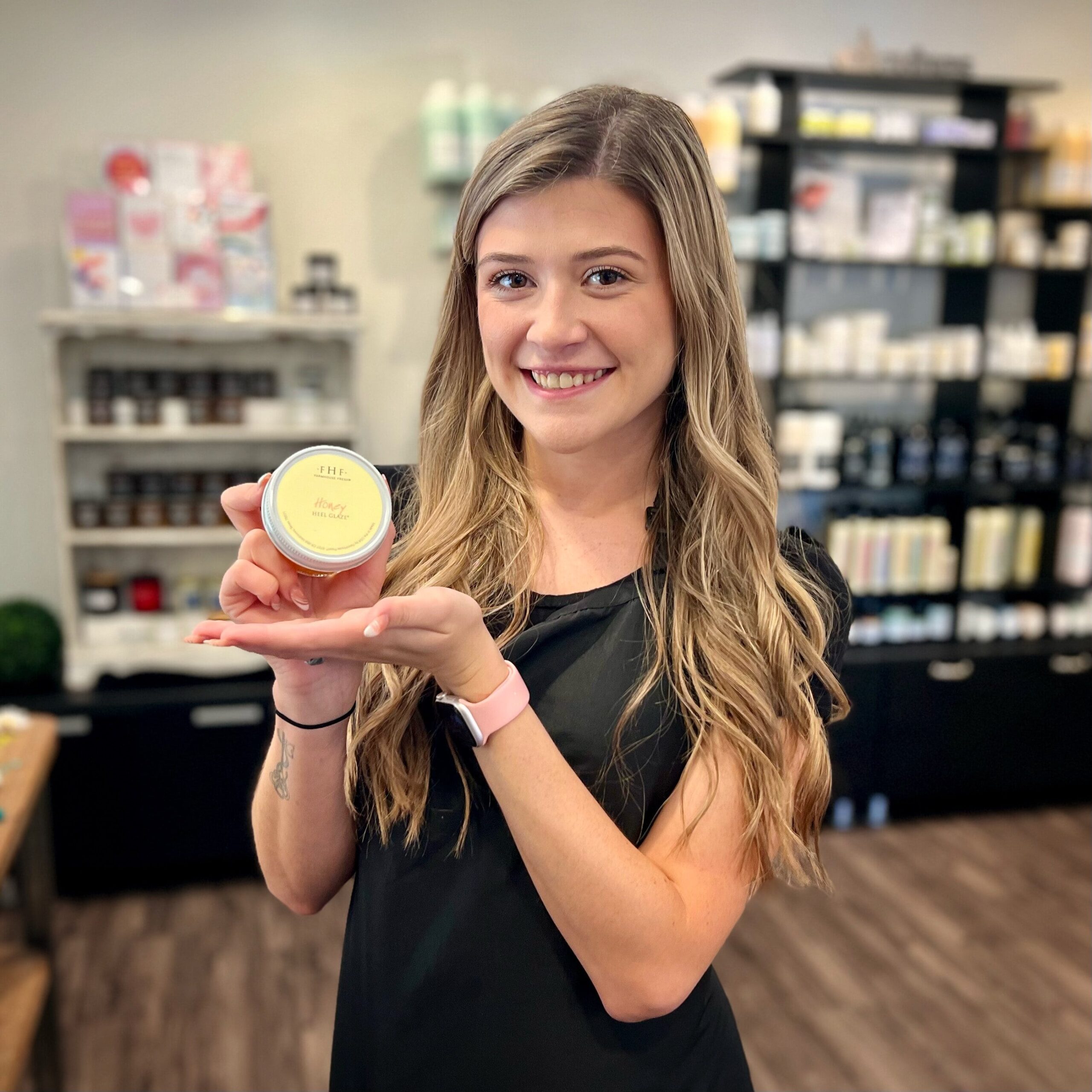 Our hair stylist Jaidyn holds FarmHouse's Fresh Honey Heel Glaze.