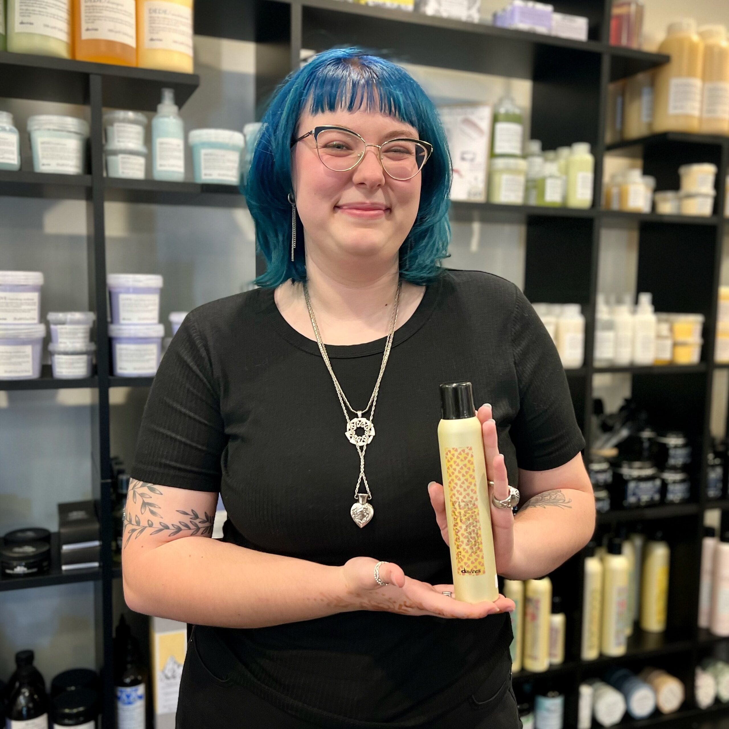 Our guest services representative Becca holds Davines' This Is A Dry Wax Spray.