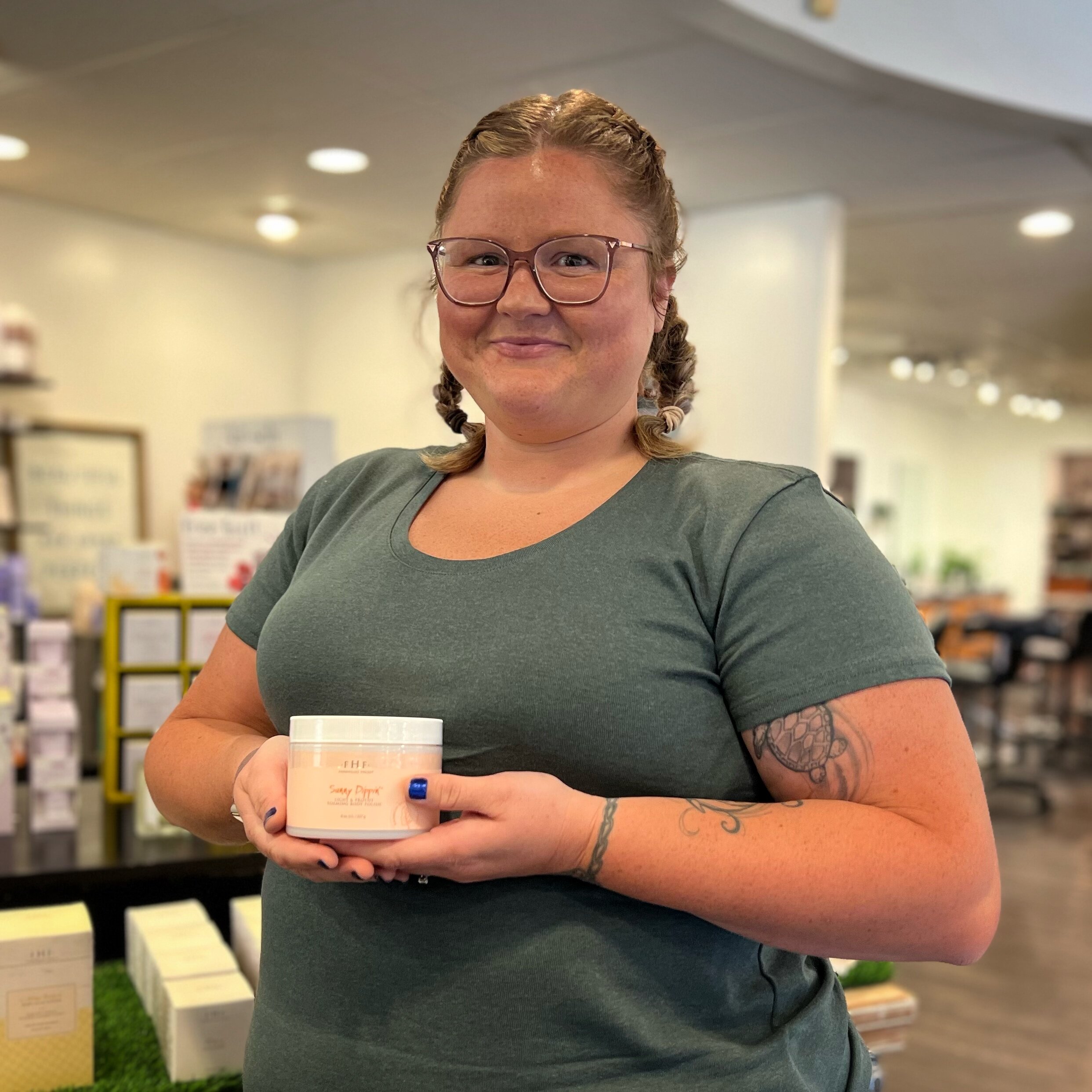 Our guest services representative Tia holds FarmHouse Fresh's Sunny Dippin' Foaming Body Polish.