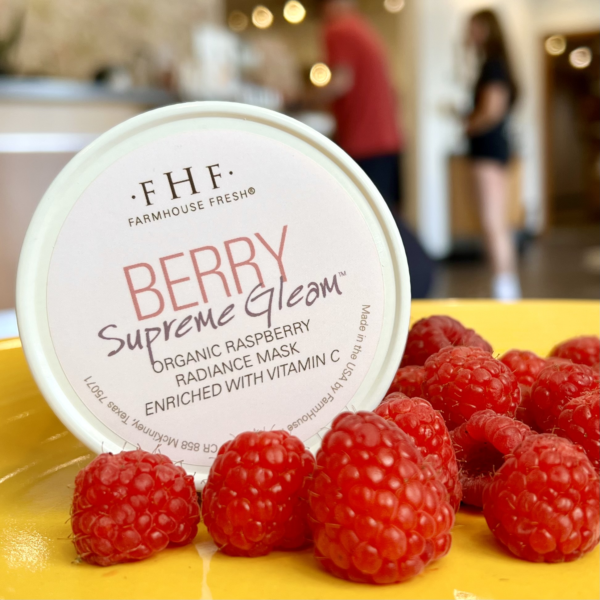 FarmHouse Fresh's Berry Supreme Gleam Radiance Mask sits on a yellow plate with a pile of raspberries.