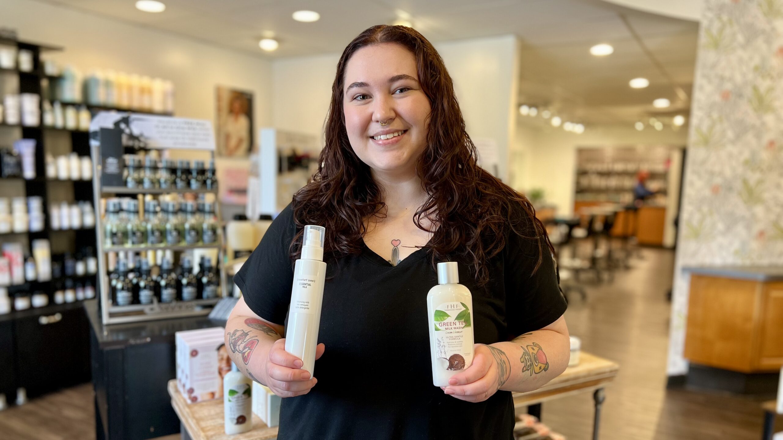 Our esthetician Morgan holds FarmHouse Fresh's Green Tea Milk Wash and Comfort Zone's Essential Milk.