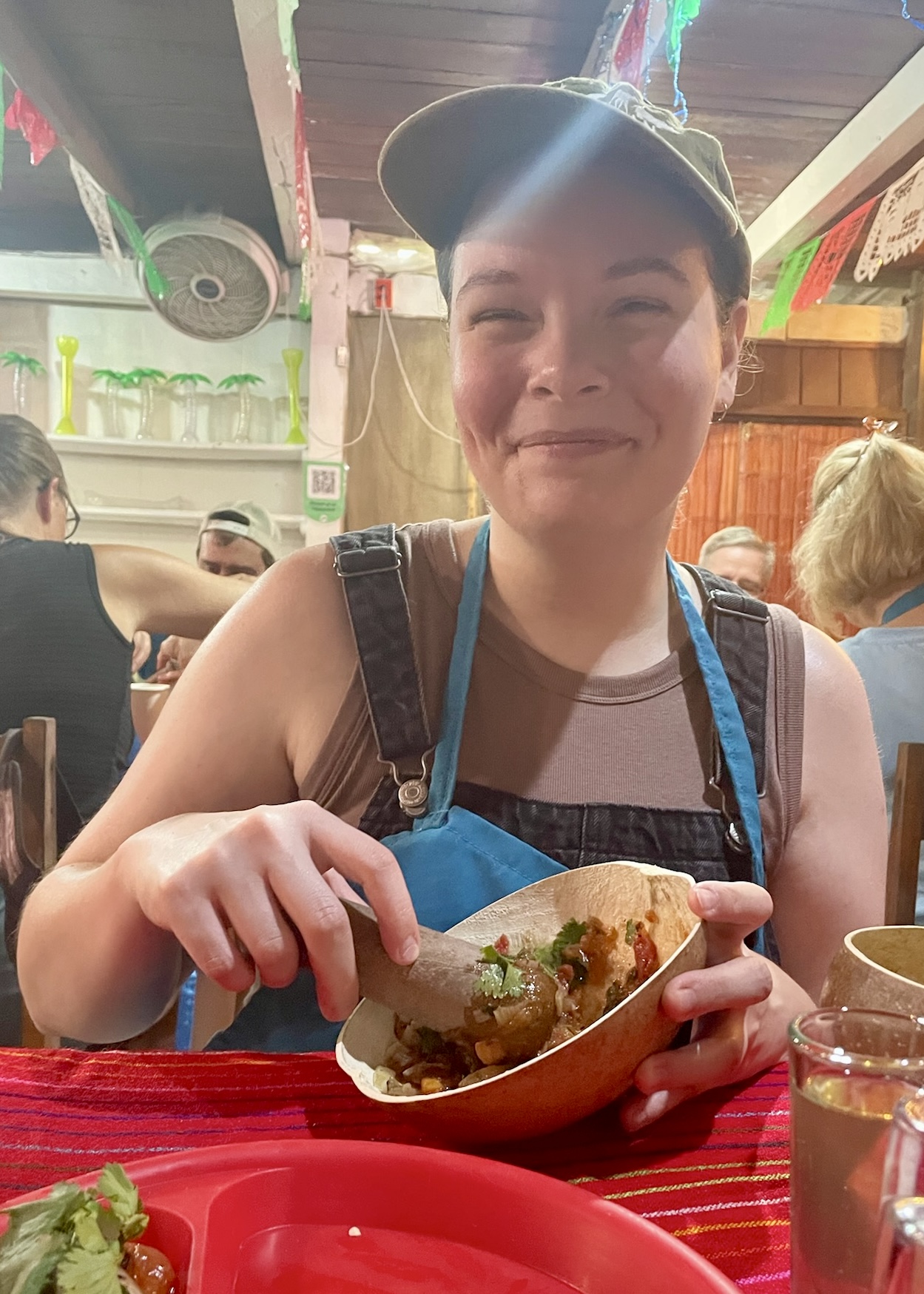 I smile for a photo as I grind ingredients with a pestle during our salsa-making class in Mahahual, Mexico.