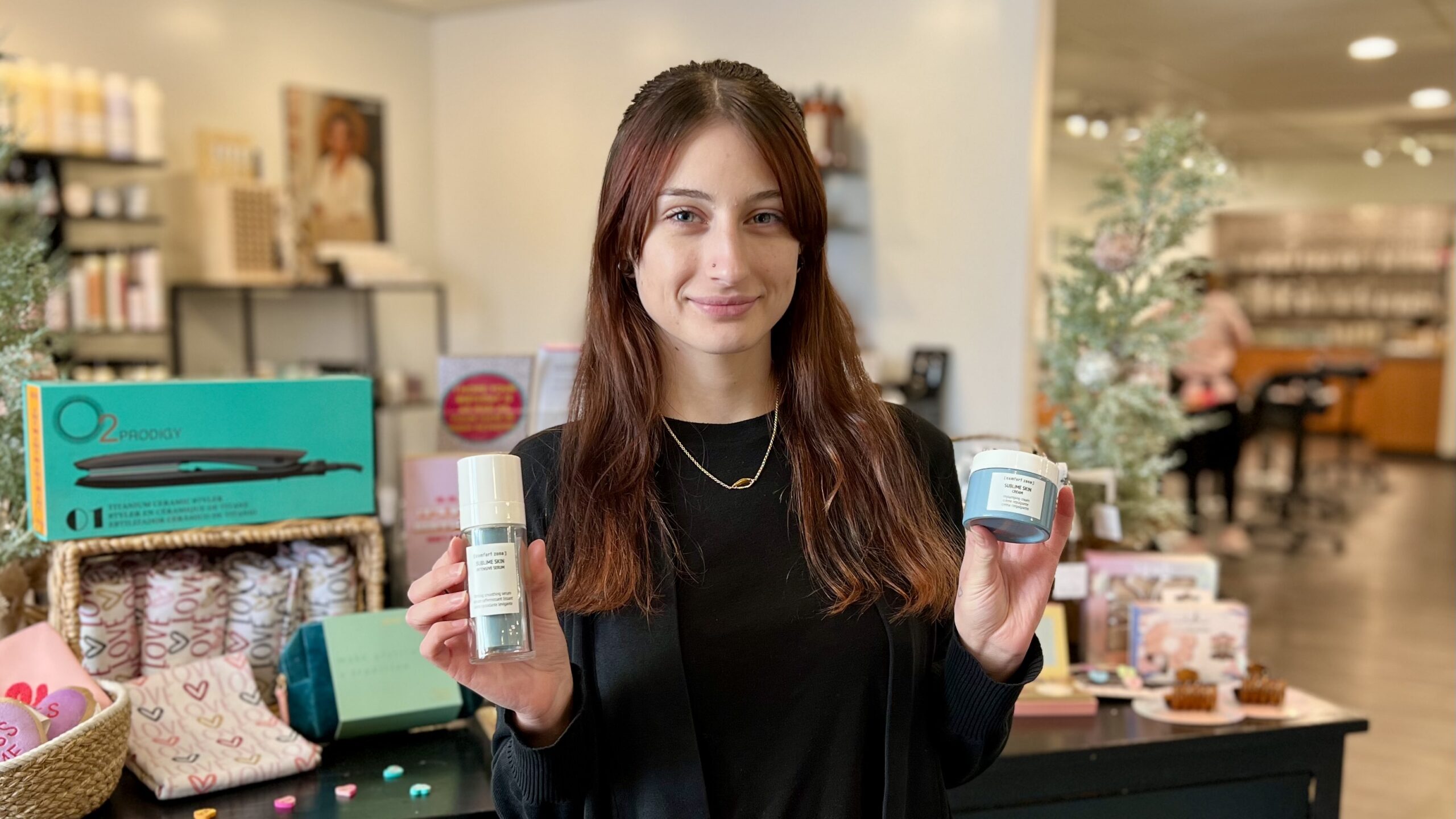 Our esthetician Nicole holds Comfort Zone's Sublime Skin Intensive Serum and Rich Cream, two recommend products to care for the skin on your neck and decollete.