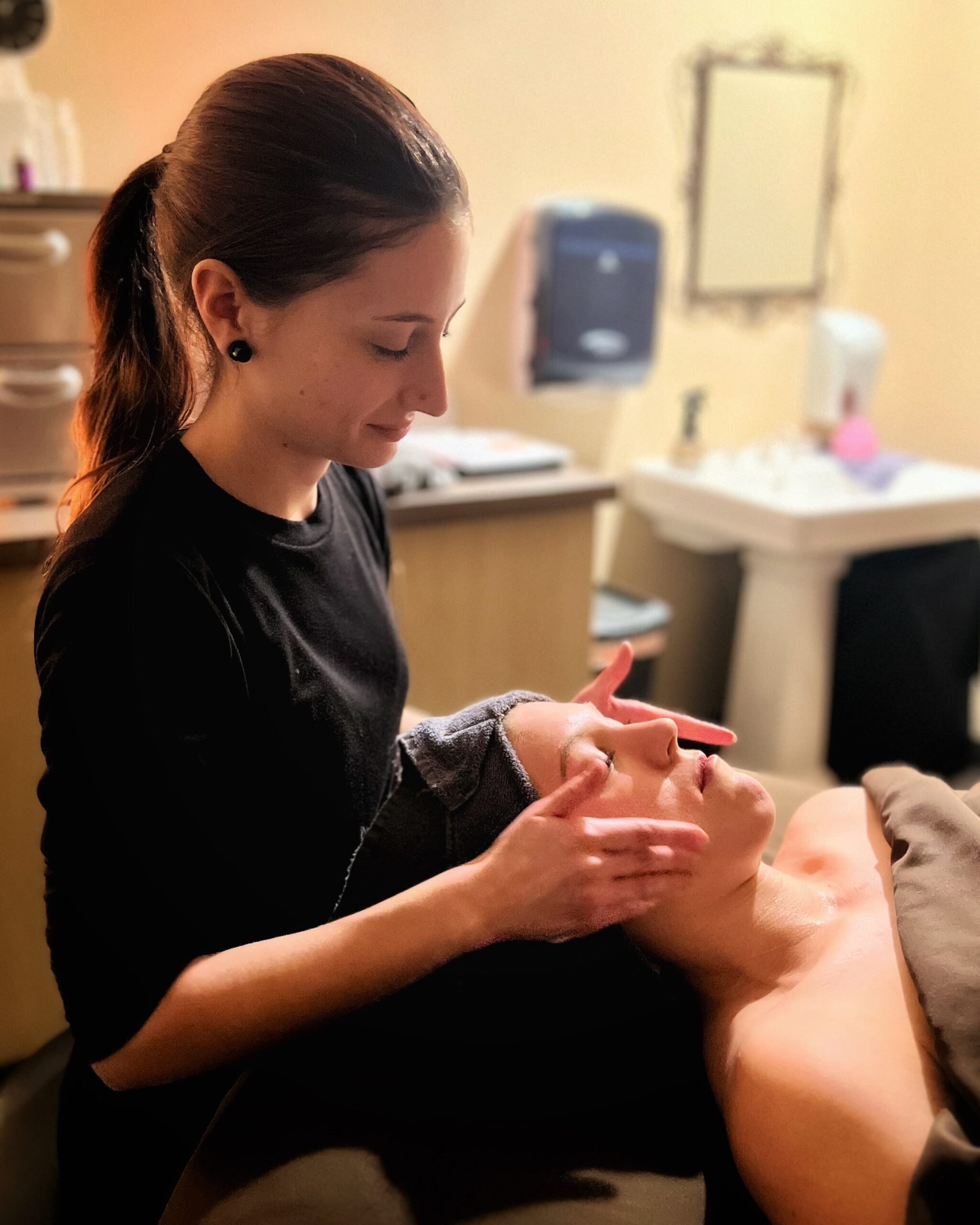 Our esthetician Nicole gives our marketing director Mallorie's a massage during her facial.