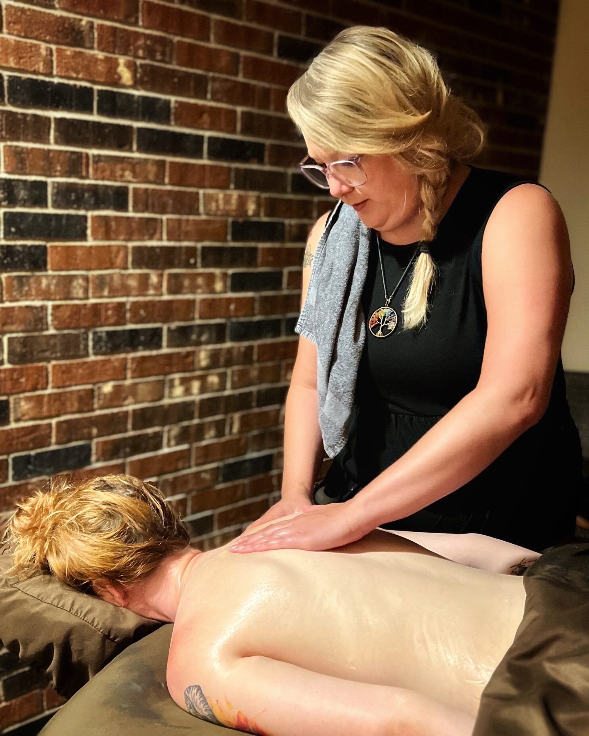 Our massage therapist Sara works on her guest's shoulder and back during her Darling Clementine Ritual Massage.