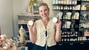 Our daily operations manager Mallorie holds FarmHouse Fresh's Honey Heel Glaze and Sunflower Honey Butter