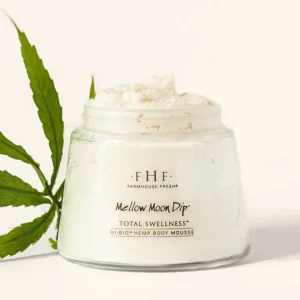 A jar of Serene Moon Dip® Back To Youth Ageless Body Mousse (Copy) is displayed beside a green leaf on a light background. - Tyler Mason Salon + Spa in Indianapolis, IN