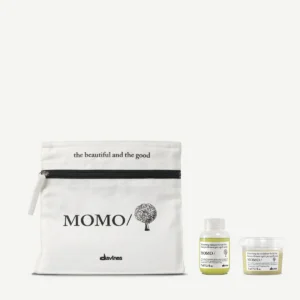 The minu travel/discovery kit includes a white zip pouch labeled "MOMO/ Davines" with "the beautiful and the good" above it, holding two small containers of Davines shampoo and conditioner. - Tyler Mason Salon + Spa in Indianapolis, IN