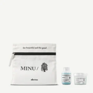 A minu travel/discovery kit includes a white zippered pouch labeled "MINU" with two small hair care bottles—one containing blue liquid and the other, white cream. - Tyler Mason Salon + Spa in Indianapolis, IN