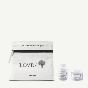 A white zipper pouch labeled "LOVE/" with two small bottles of Love Smoothing Perfector placed beside it on a plain background. - Tyler Mason Salon + Spa in Indianapolis, IN